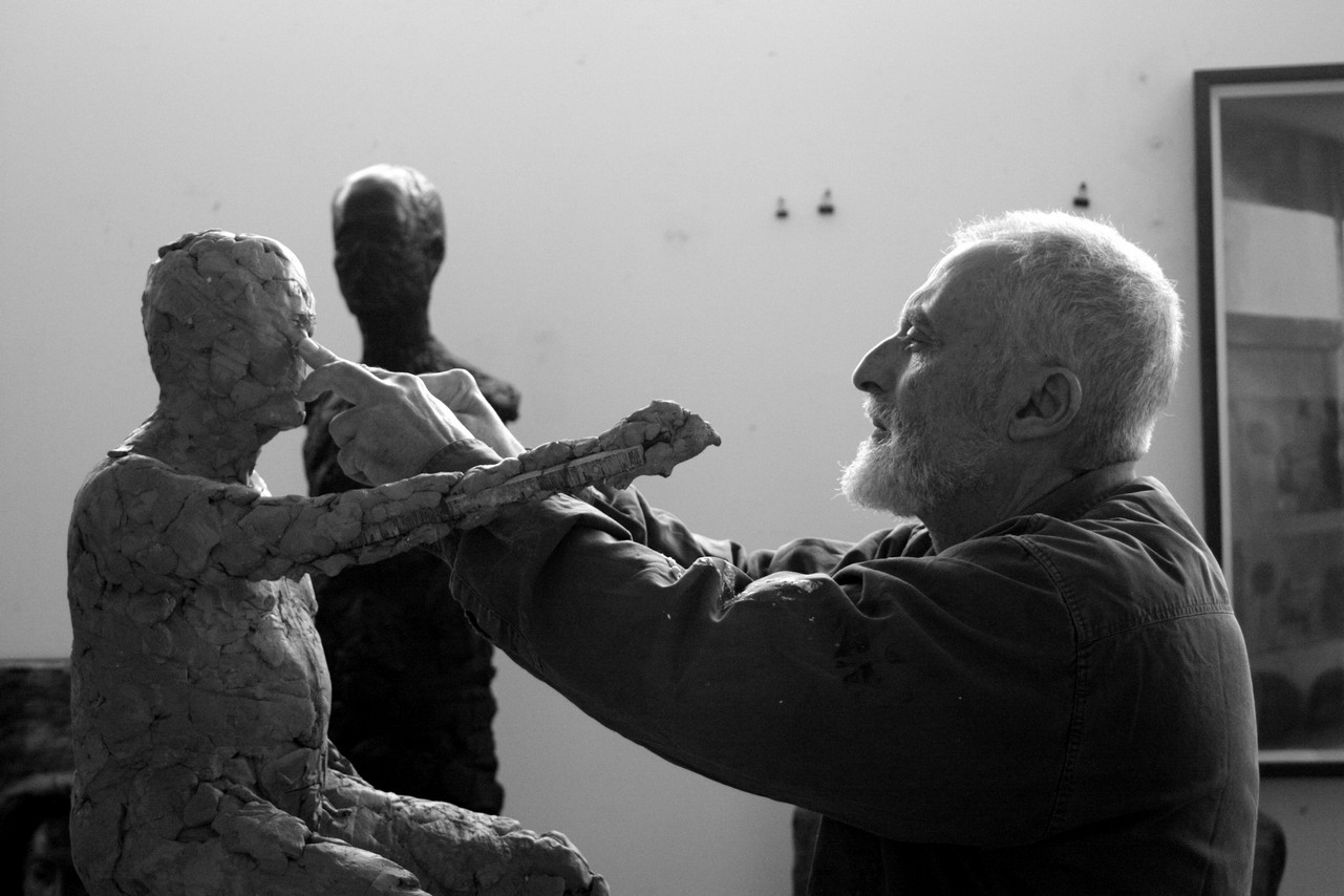 Ofer Lellouche in dialogue with a self-portrait sculpture in progress.** Photograph by Gila Orkin