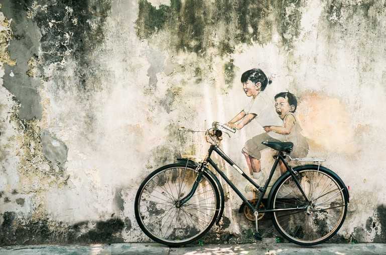 Children riding a real bicycle incorporated into the mural. Photo: Shutterstock
