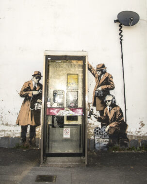 A Banksy mural painted around a public telephone booth in Cheltenham, England (2014). Photo: Shutterstock