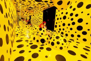 Japanese artist Yayoi Kusama appears inside one of her immersive installations filled with endless dots — the visual motif that has become her artistic signature. Photo: Shutterstock