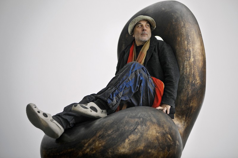 Arad sitting on his “Drunken Bodyguard” chair, made from polished aluminum and characterized by his signature curved design language.Photo: Ron Arad And Associates Ltd