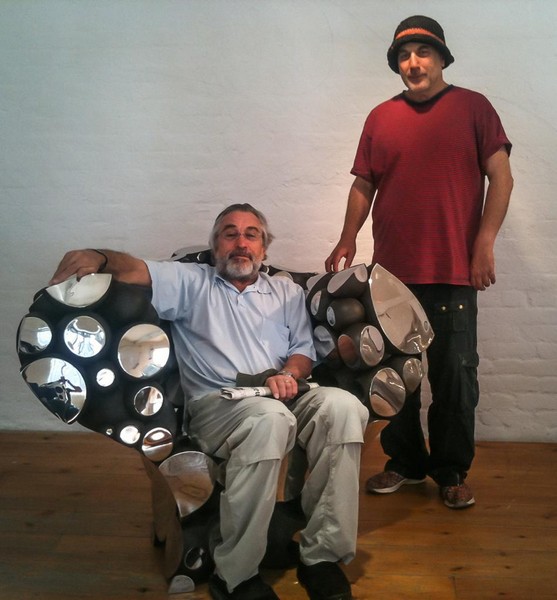 Actor Robert De Niro visiting Arad’s studio, seated on the stainless-steel “Even the Oddballs” chair. Photo: Ron Arad And Associates Ltd